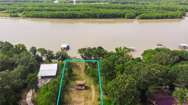 an aerial view of a house with a yard and lake view