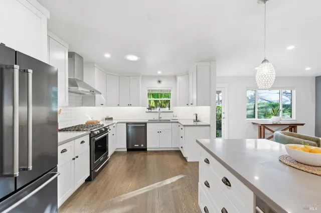 a kitchen with a refrigerator a stove and a wooden floor