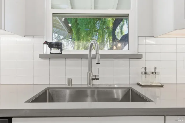 a view of a dining room with furniture a kitchen and chandelier