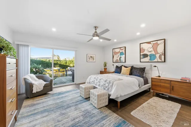 a spacious bedroom with a bed a ceiling fan and a couch