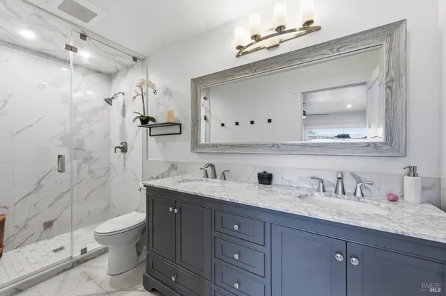a bathroom with a granite countertop sink a toilet and shower