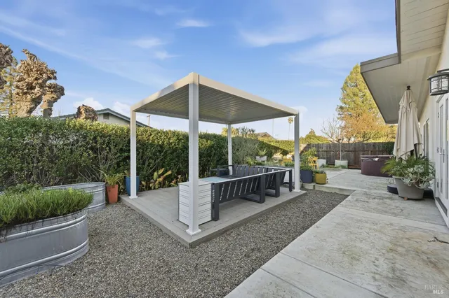 a view of a patio with couches chairs potted plants and floor to ceiling window and potted plants