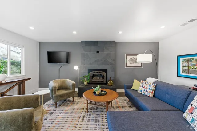 a living room with furniture kitchen view and a large window
