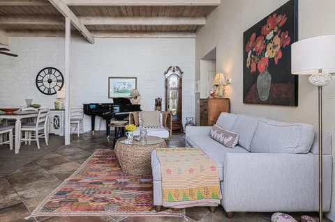 a living room with furniture a clock on wall and a table