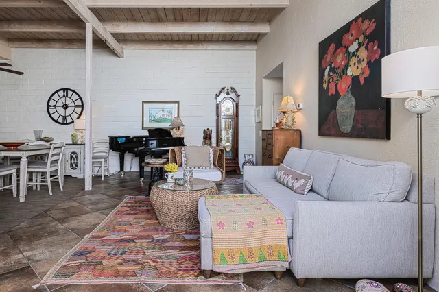 a living room with furniture a clock on wall and a table