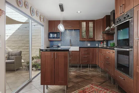 a kitchen with stainless steel appliances granite countertop a stove a sink and a microwave