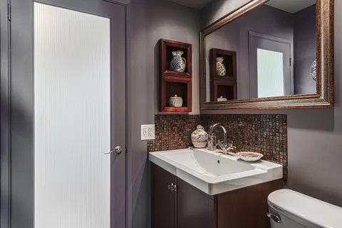 a bedroom with a bed a computer on the desk and a dresser next to a window