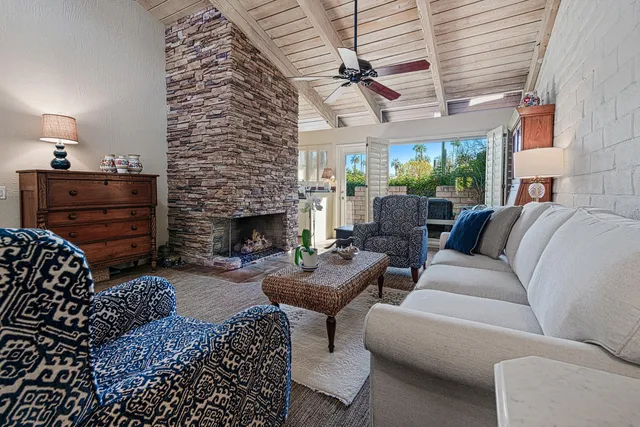 a living room with furniture a fireplace and a floor to ceiling window