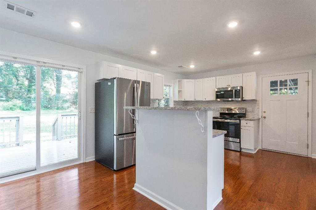 4144 Canby Lane Decatur, GA 30035 - Photo 4 of 6 a kitchen with stainless steel appliances granite countertop a refrigerator a stove a sink and a microwave