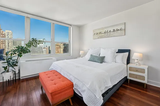 a bedroom with bed and a potted plant