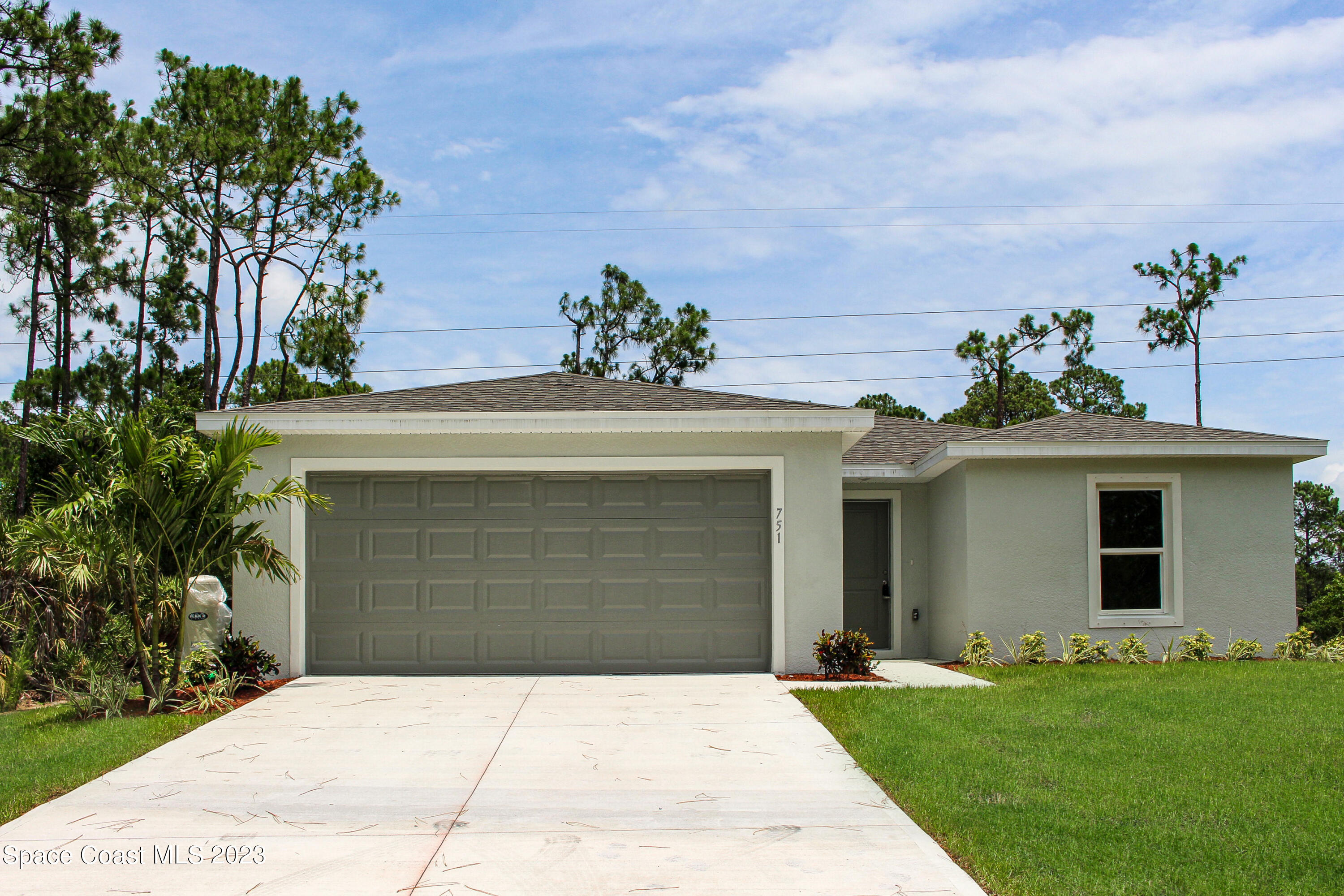 751 Schean Avenue Southwest Palm Bay, FL 32908 - Photo 1 of 12 a front view of a house with a garden