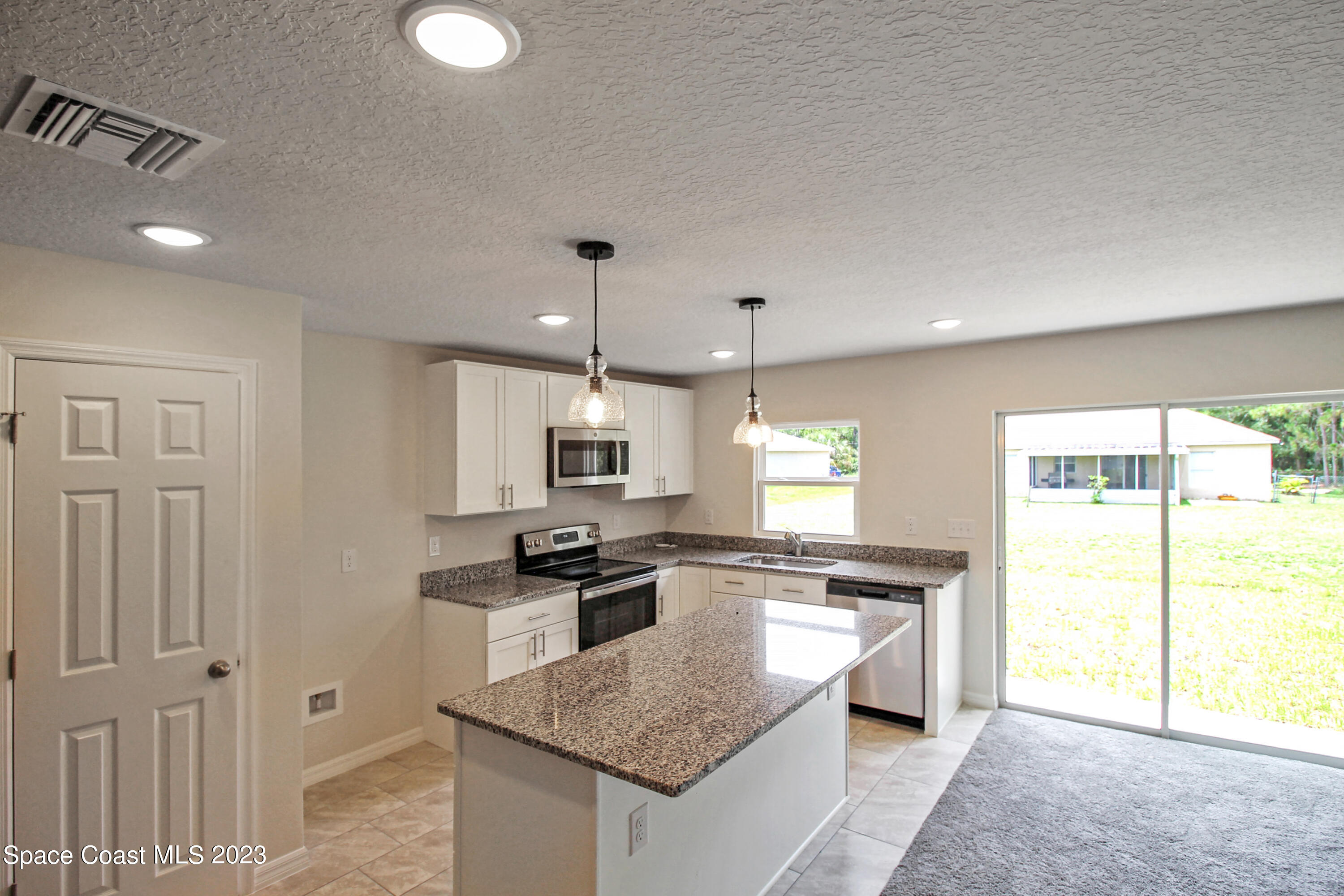 751 Schean Avenue Southwest Palm Bay, FL 32908 - Photo 3 of 12 a kitchen with stainless steel appliances granite countertop a sink stove and refrigerator