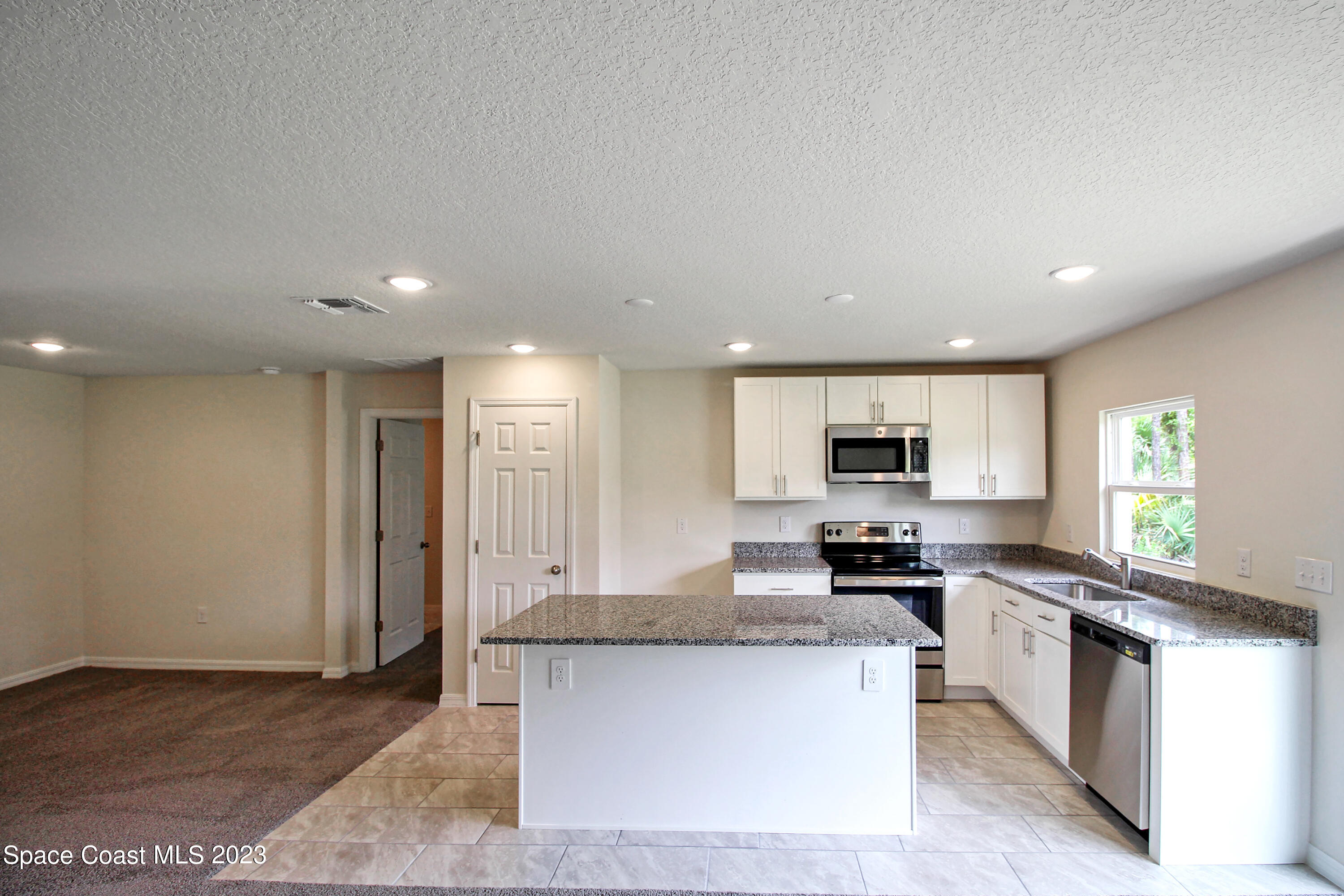 751 Schean Avenue Southwest Palm Bay, FL 32908 - Photo 4 of 12 a kitchen with stainless steel appliances granite countertop a stove top oven a sink and a granite counter tops