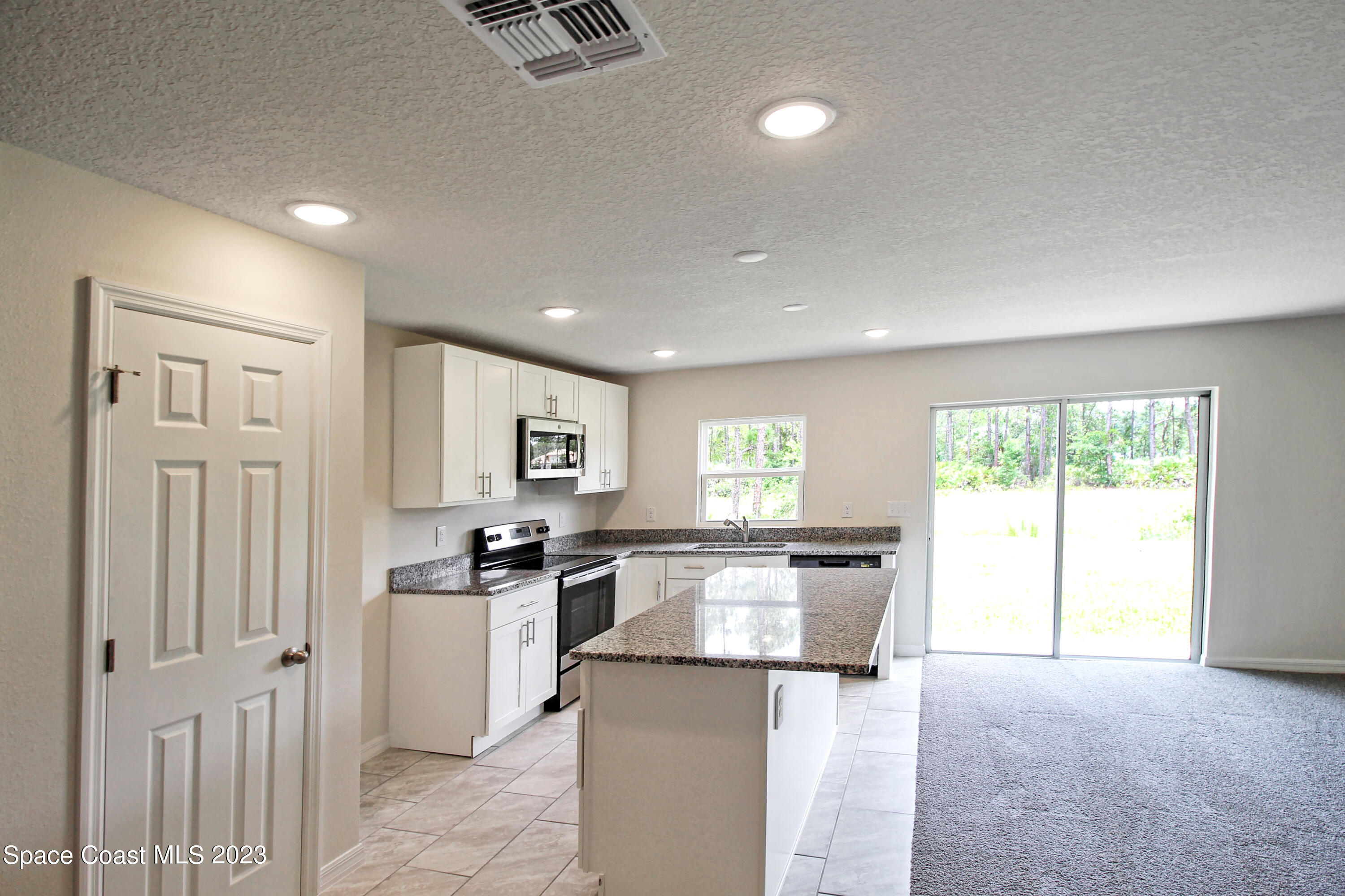 751 Schean Avenue Southwest Palm Bay, FL 32908 - Photo 5 of 12 a kitchen with stainless steel appliances granite countertop a stove a sink and a refrigerator