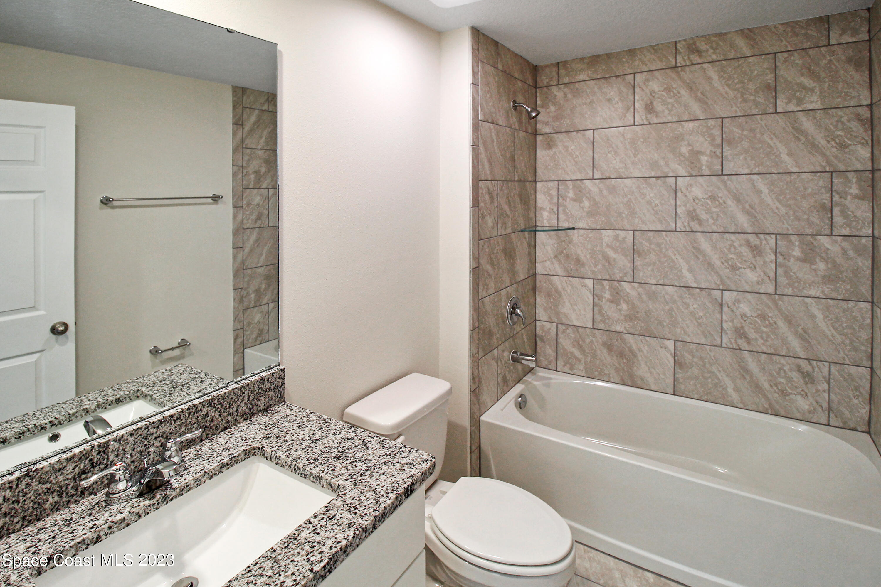 751 Schean Avenue Southwest Palm Bay, FL 32908 - Photo 7 of 12 a bathroom with a granite countertop bathtub toilet and sink