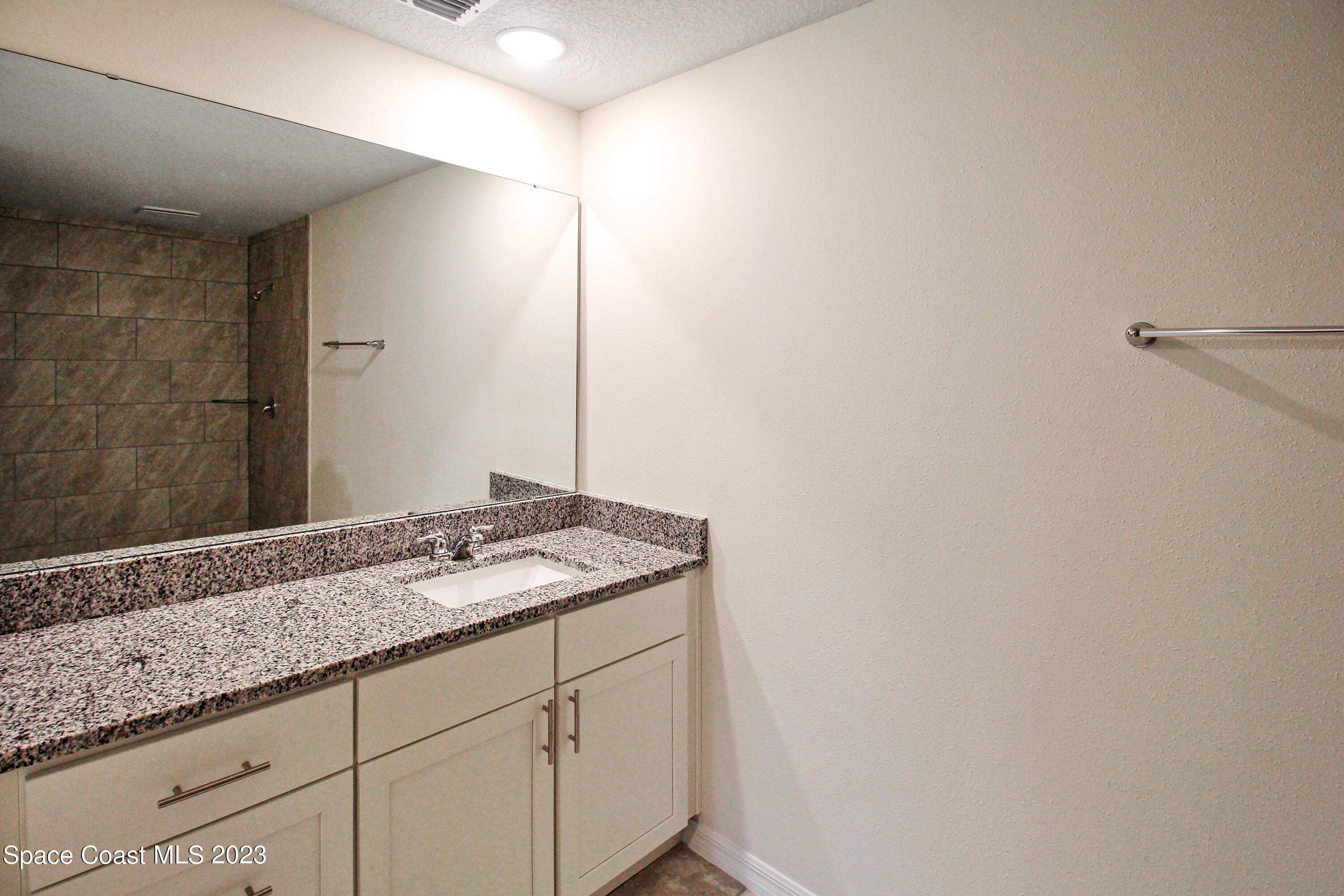 751 Schean Avenue Southwest Palm Bay, FL 32908 - Photo 8 of 12 a bathroom with a granite countertop sink and a mirror