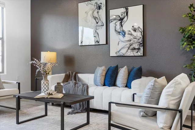 a living room with furniture and a wall painting