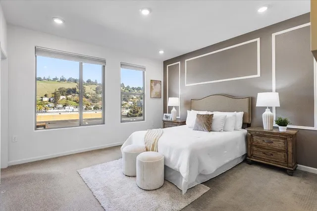 a bedroom with a bed and a large window