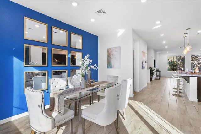 a view of a dining room with furniture a kitchen and chandelier
