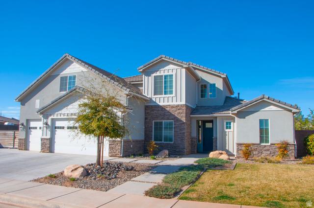 429 East Treasure Road Washington, UT 84780 - Photo 2 of 36 View of front facade featuring stone siding, concrete driveway, an attached garage, and board and batten siding