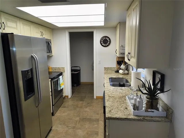 a kitchen with stainless steel appliances granite countertop a refrigerator and a stove