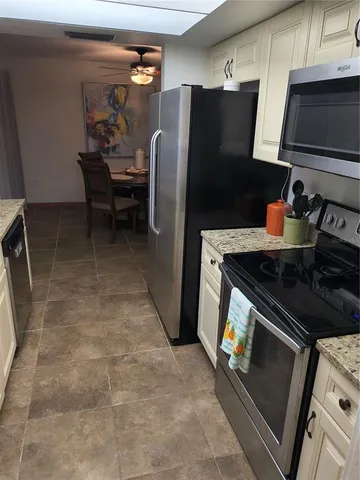 a kitchen with stainless steel appliances granite countertop a refrigerator and a stove top oven