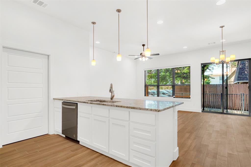 3676 Rickshaw Drive, Unit A Dallas, TX 75229 - Photo 6 of 21 view of kitchen bar adjacent to range & refrigerator. Pantry opens with Sliding doors to the left of dishwasher. See private patio with iron fence thru sliding patio doors.