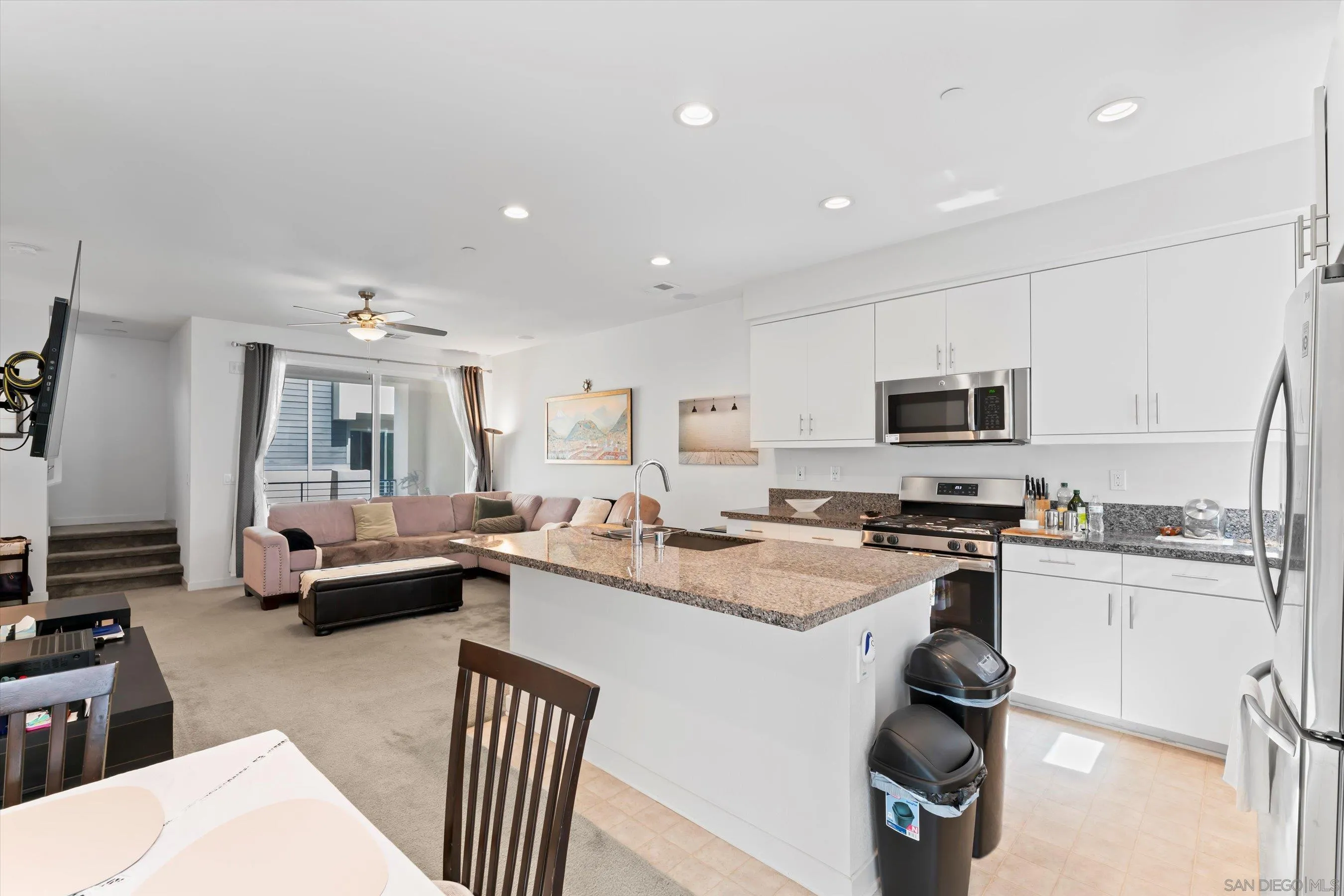 2275 Element Way, Unit 4 Chula Vista, CA 91915 - Photo 14 of 45 a kitchen with stainless steel appliances a stove a sink a refrigerator white cabinets and couches with wooden floor