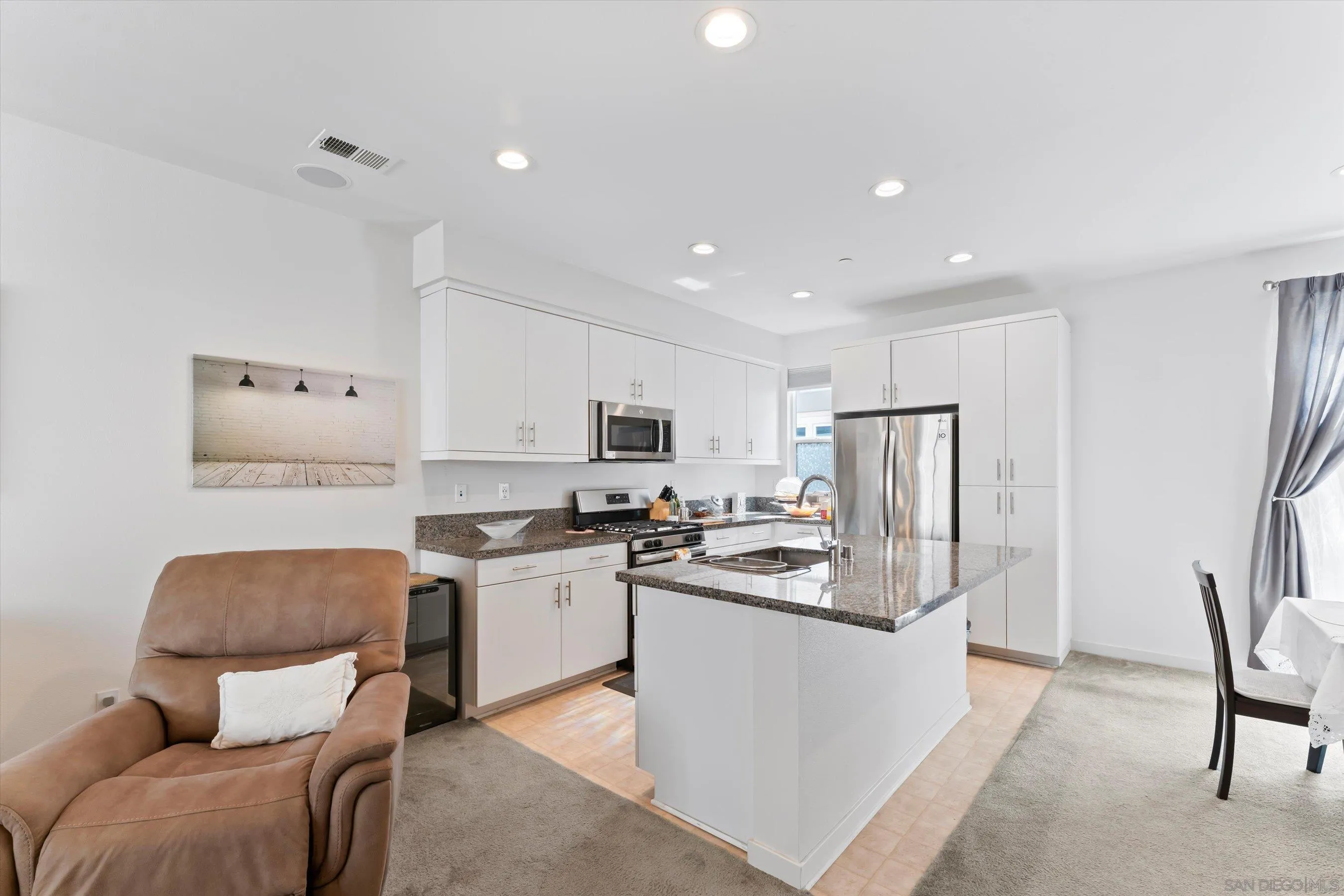 2275 Element Way, Unit 4 Chula Vista, CA 91915 - Photo 8 of 45 a kitchen with stainless steel appliances granite countertop a refrigerator a stove a sink a dining table and chairs with wooden floor