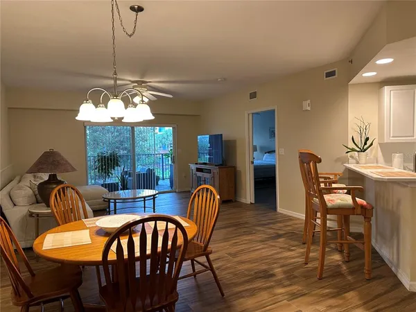a dining room with furniture a chandelier and wooden floor