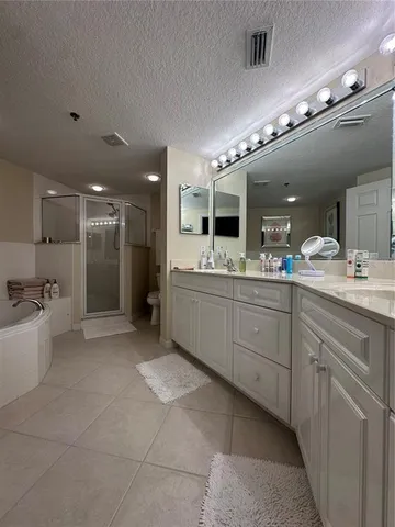 a large bathroom with a large mirror vanity and shower