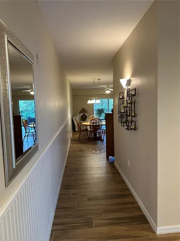 a view of a hallway with wooden floor and stairs