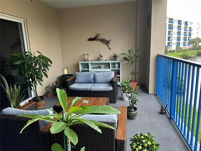a dining room with furniture potted plants and wooden floor