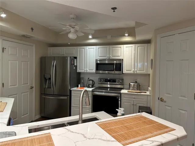 a kitchen with stainless steel appliances granite countertop a refrigerator stove and sink