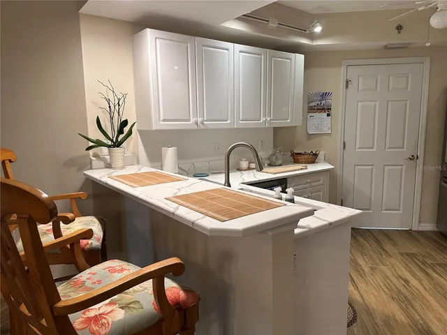 a kitchen that has a sink and a stove with wooden floor