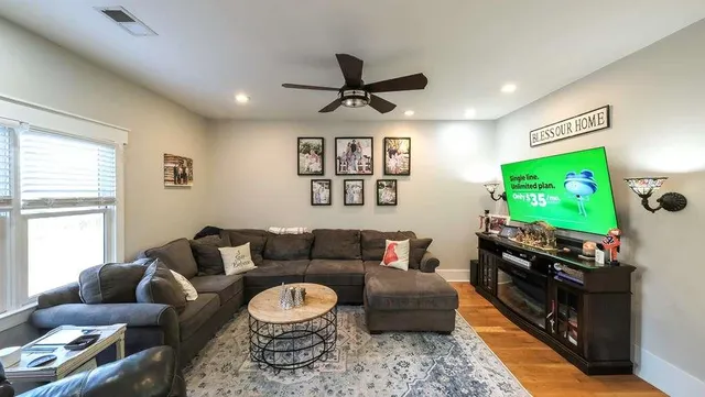 a kitchen with stainless steel appliances kitchen island granite countertop a stove a refrigerator a sink a dining table and chairs with wooden floor