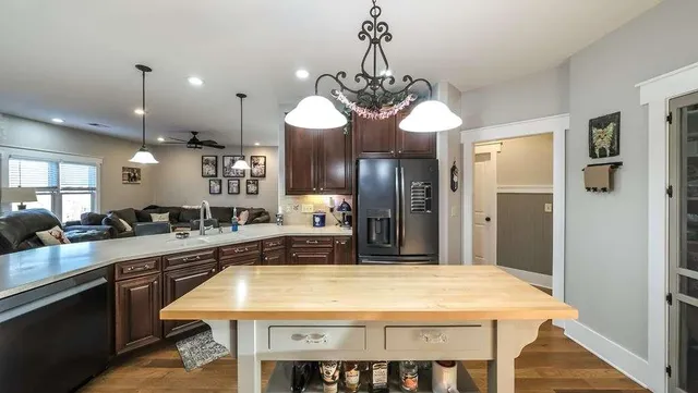 a kitchen with stainless steel appliances granite countertop a refrigerator a oven a kitchen island a stove and a sink