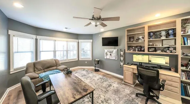 a living room with furniture a flat screen tv and a large window