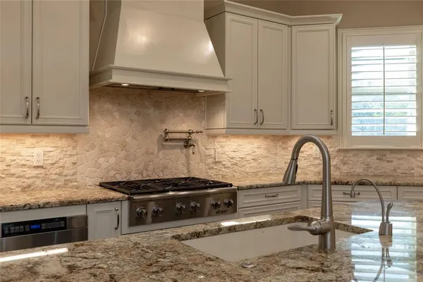 a kitchen with granite countertop a stove and a sink