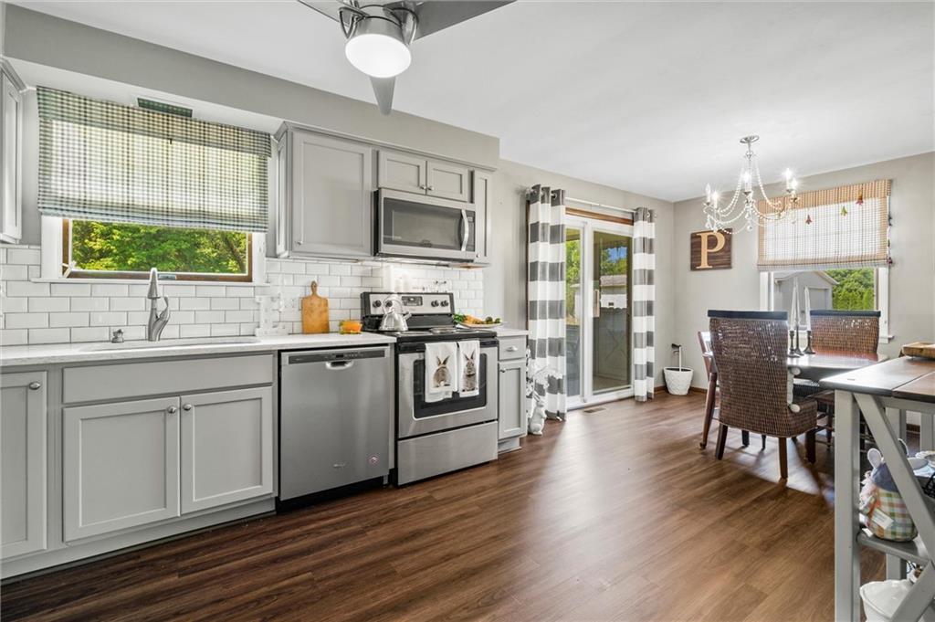 545 Bedford Road West Middlesex, PA 16159 - Photo 2 of 25 a kitchen with stainless steel appliances granite countertop a stove top oven a sink dishwasher a dining table and chairs with wooden floor
