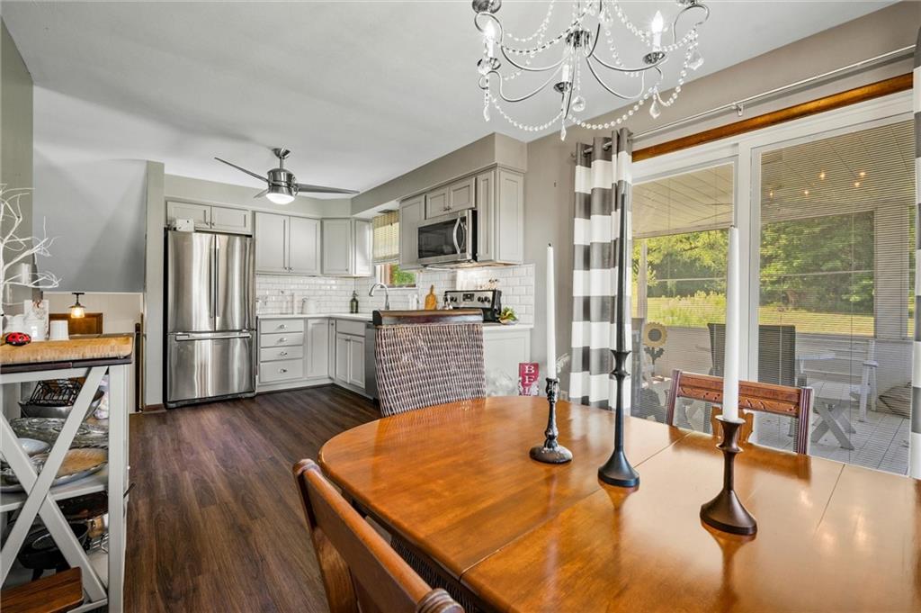 545 Bedford Road West Middlesex, PA 16159 - Photo 4 of 25 a kitchen with stainless steel appliances granite countertop a refrigerator a stove and a dining table with wooden floor