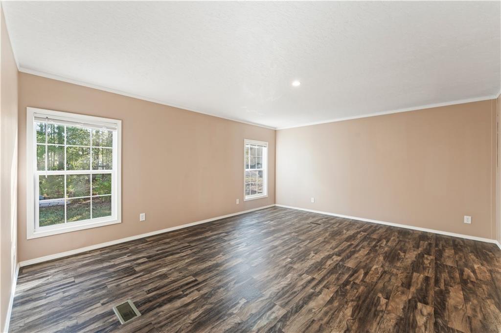 89 Ridge Road Seale, AL 36875 - Photo 20 of 46 Spacious room featuring wood-finish flooring, neutral-toned walls, multiple windows, and a recessed ceiling light