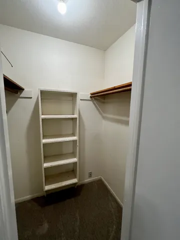 a view of walk in closet with empty racks