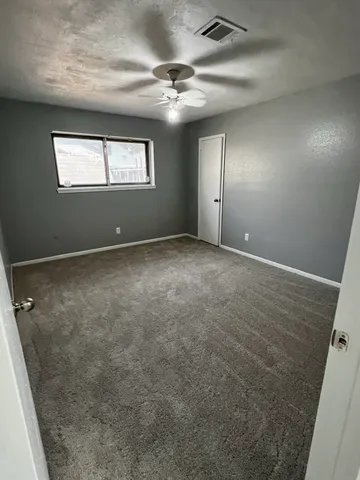 an empty room with windows and closet
