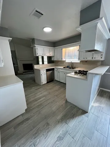 a kitchen with a sink cabinets and wooden floor