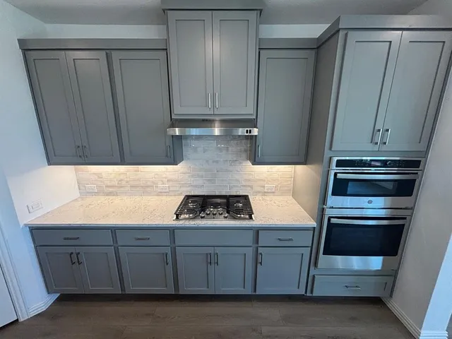 a kitchen with stainless steel appliances a sink window and wooden floor