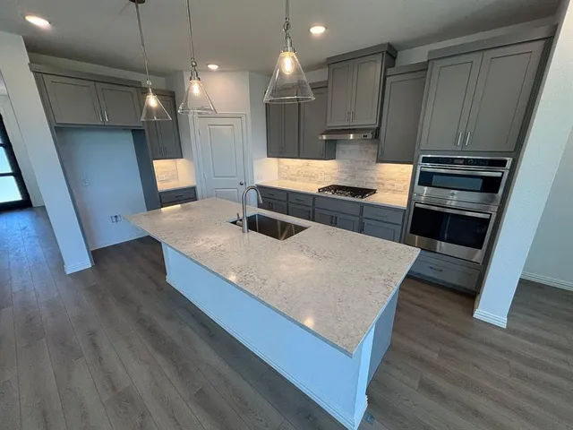 a view of an empty room with wooden floor and cabinet