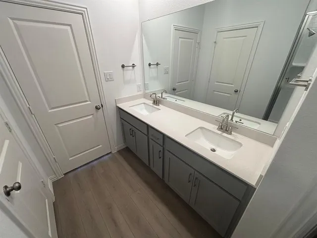 a bathroom with a double vanity sink and mirror