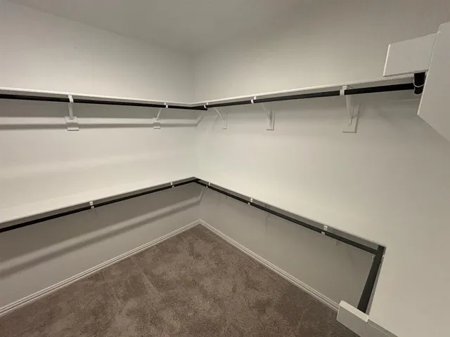 a view of walk in closet with empty racks
