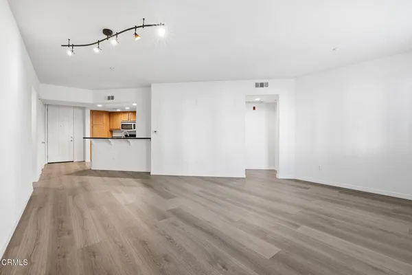 a view of a big room with wooden floor and windows
